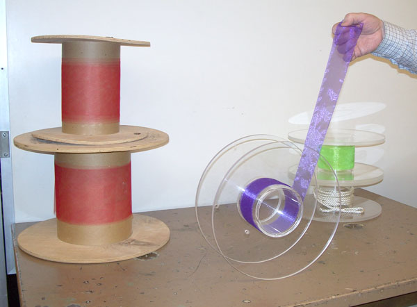 Spools of different diameters with rope or ribbon wound on the spindle