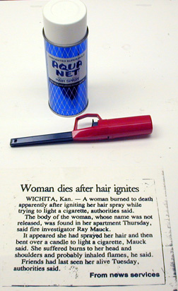 can of hair spray, lighter, newspaper clipping "Woman dies after hair ignites"