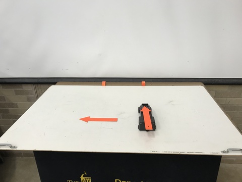 toy car on a cardboard sheet with two arrows