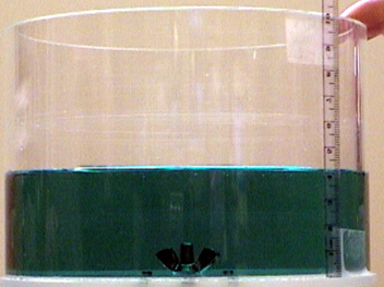 green liquid in a container, a ruler measuring depth