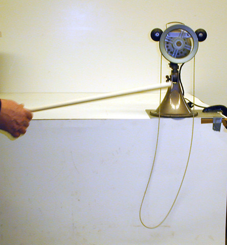 fan motor, pulley, a continuous loop of chain, person pointing to demo with a dowel