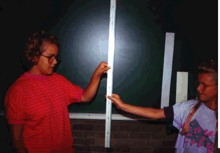 two people holding a ruler