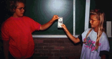 two girls holding a dollar bill