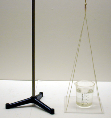 beaker half full of water on a platform, stand