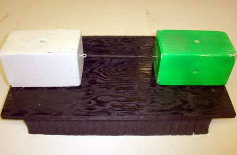 Two large blocks of equal size, connecting spring, Plywood shelf