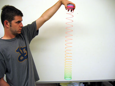 man holding an extended Slinky