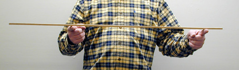 person holding a meter stick with two fingers far apart