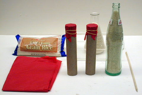 Pop bottle, rice, pointed wooden dowel, tissue paper, rubber bands, tablecloth, container and cardboard tubes