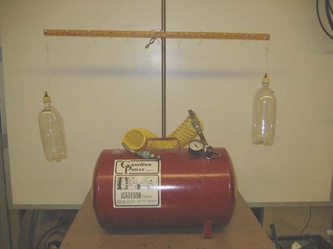 Bottles Balanced on a beam with an air compressor