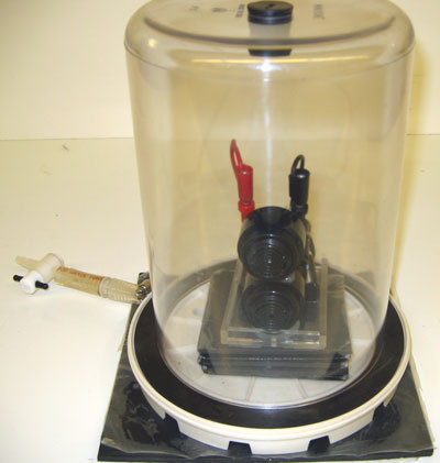 Bell jar with sorbothane pad, vacuum pump, 6 volt battery with attached doorbell.