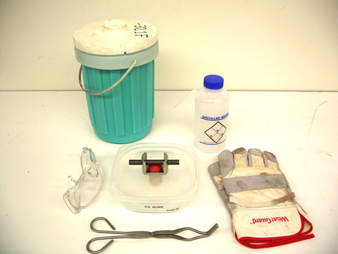 Ice Bomb Unit with Movable Plunger, Cast Iron Rods, Liquid Nitrogen, and Shallow Plastic Container.