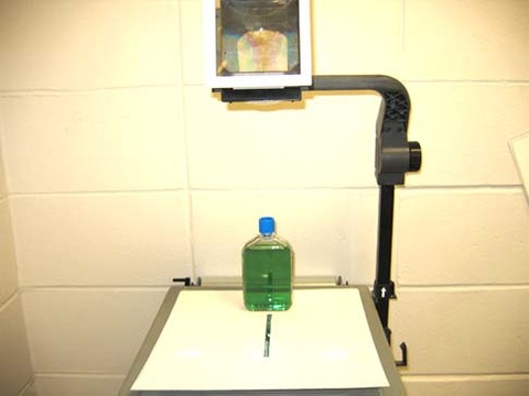 Projector with Bottle of Green Liquid