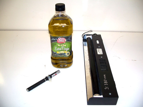 bottle of olive oil, laser pointer, black light