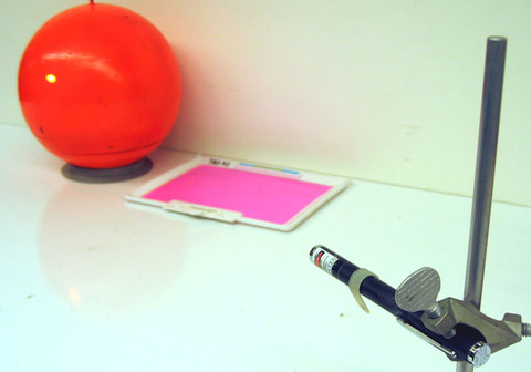 orange sphere, fluorescent sheet, laser pointer on a stand