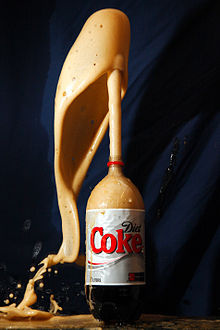 foamy Diet Coke gushing out of a liter bottle